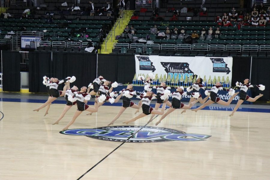 While leaping in the middle of their performance, the Silver Stars team perform at the State championships at the Family Arena in St. Charles. With the highest overall score in the 4A divison, the girls won first on Feb. 26. ( Photo used with permission by Shea Turner.)