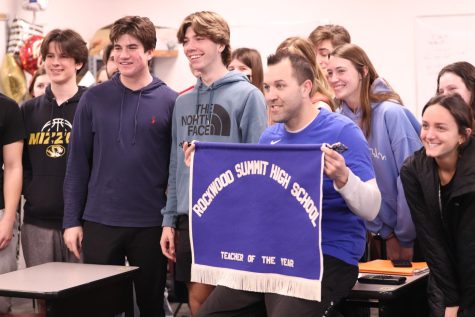 With his Algebra 2 class, math teacher Samuel Haug holds up his Teacher of the Year banner after winning. On Feb. 22, the administration interrupted to give Haug his award.