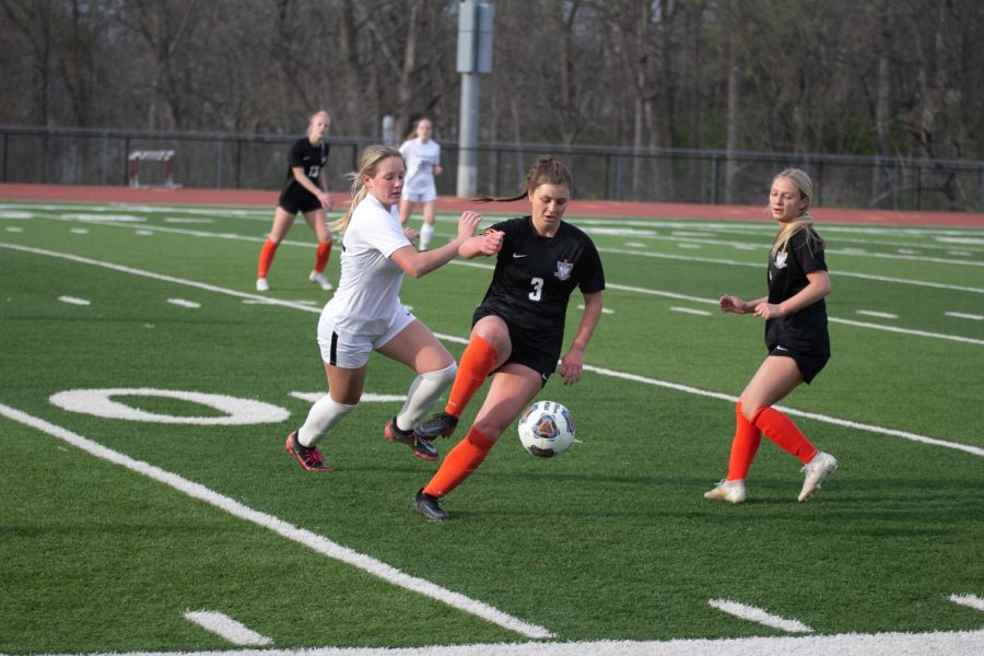 Senior Rylie Morris pushes past Ellie Paloucek of
Webster as she recives the ball from junior Megan
Larocque. The girls soccer team defeated Webster
Groves 2-1 at home on April 19. 