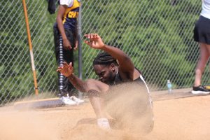 Senior Samad Mounger lands in the sand after performing the long jump. Mounger placed 6th, jumping 6.00m.
Both the boys and girls teams placed 1st at the District championship on May 14.