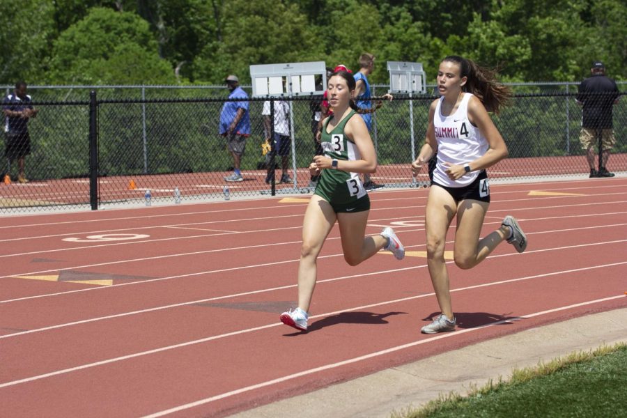 Sophomore Mia Brown (4) passes Madelyn Schillinger (3) of Nerinx Hall in the 800 meter race. Brown ran
a time of 2:27.43 in the meet. Both track teams placed first at Districts on May 14.