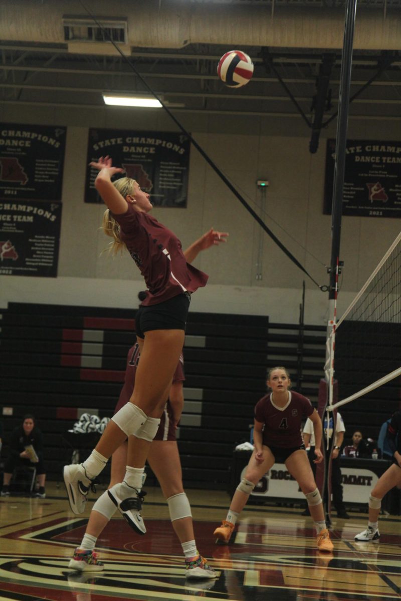 Preparing to strike the ball, junior Lainey Waser leaps up as Senior Jordan Vaughan watches attentively.  Volleyball beat Parkway South in straight sets on Aug. 8. 