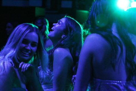 As she looks into the lights, senior Ali Findley dances alongside senior Lily Tarticchio. The snowball themed dance took place on Feb. 11.
