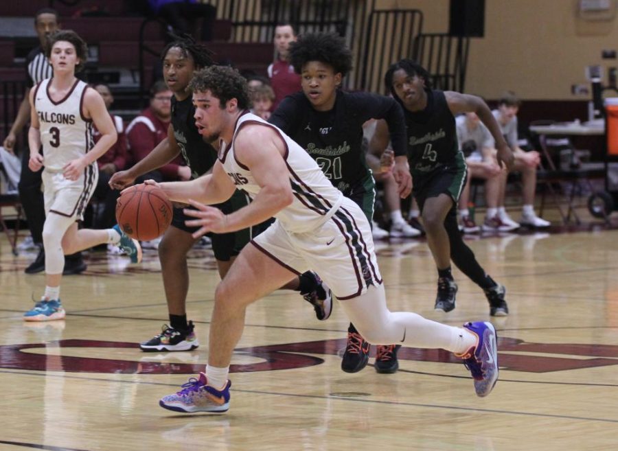 As he dribbles down the court, senior Dominic Nenninger (0) looks to pass the ball. The Falcons lost their first district game to St. Mary’s 70-56 on March 1 at Cardinal Ritter.