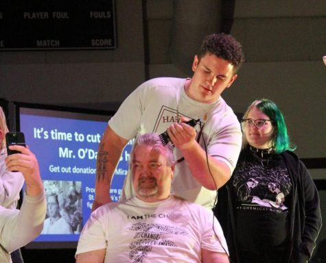 Senior Brayden Hodges shaves math teacher John Gilbert’s head during the Academic Pep Assembly. Hodges donated money to be put in a raffle to shave Gilbert’s head.