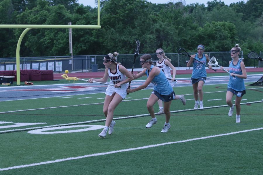 As+she+brings+the+ball+away+from+the+Falcon%E2%80%99s+goal%2C+junior+Erin+Cowie+%2813%29+gets+checked+by+Ava+Reuther+%2810%29+of+Parkway+West.+The+Falcons+beat+Parkway+West+12-0+at+home+May+15.