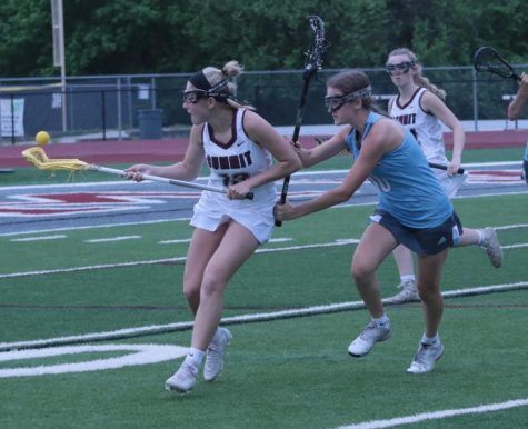 As she brings the ball away from the Falcon’s goal, junior Erin Cowie (13) gets checked by Ava Reuther (10) of Parkway West. The Falcons beat Parkway West 12-0 at home May 15.