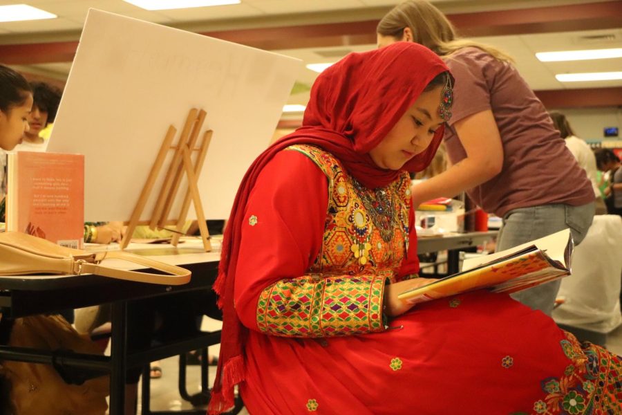 As she prepares to show her table, senior Saira Hakeem, practices reading a book she brought to represent her culture. International Night took place at Rockwood South Middle School on May 3. 