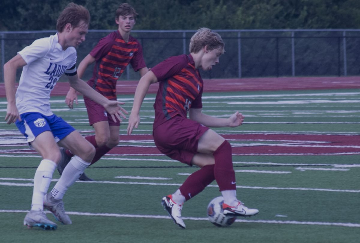 Taking control of the ball, senior Austin Conger dribbles away from
Logan Wallace (22) of Ladue as junior James Berry defends. The
Falcons defeated the Rams 2-0 at home on Sep. 5. 
