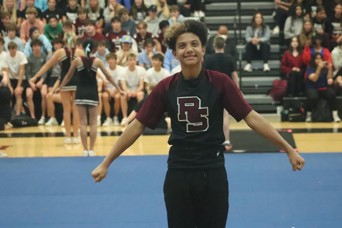As he hypes up the student section, freshman Sam Hill cheers with his teammates. The Homecoming Pep Rally took place on Oct. 6 in the Athletic Fieldhouse. 
