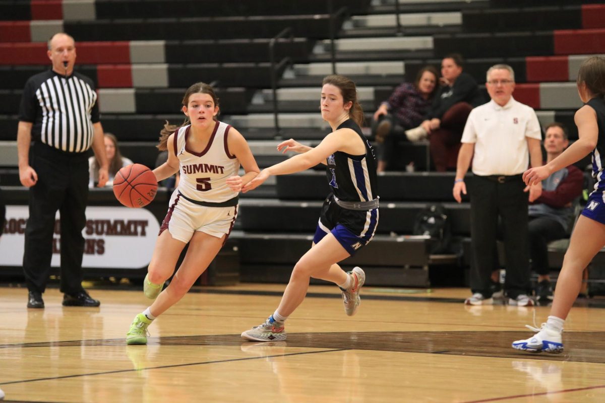 As she drives to the basket, junior Cara Rossomono (5) dribbles past the defense of Northwests Madison Hogan. For their home opener, the girls basketball team defeated the Lions 61-17. 