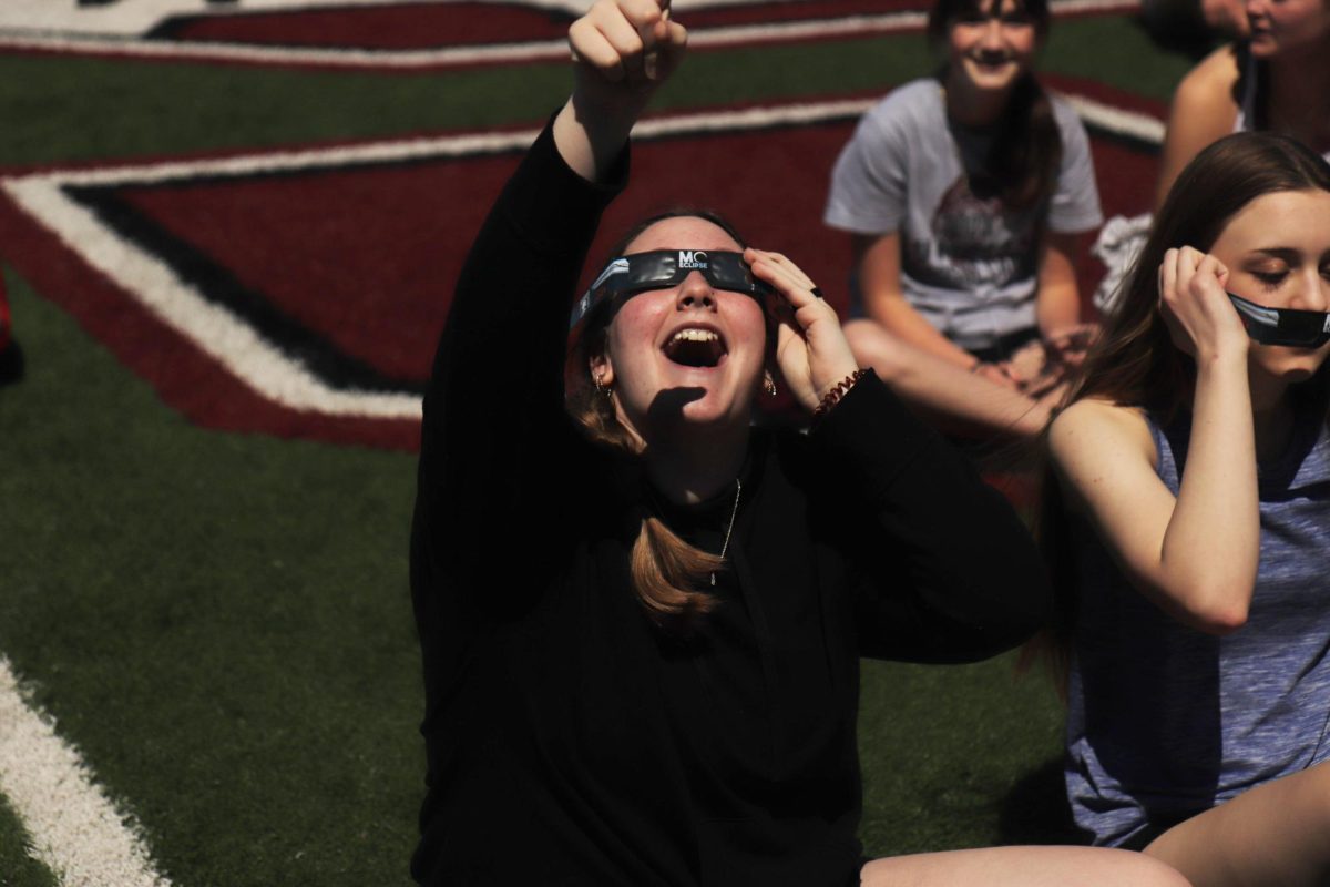 Pointing+to+the+sky%2C+freshman+Kendyll+Pike+watched+the+solar+eclipse+as+it+passes+over+Fenton.+The+school+was+able+to+witness+99+percent+totality+on+April+8.+