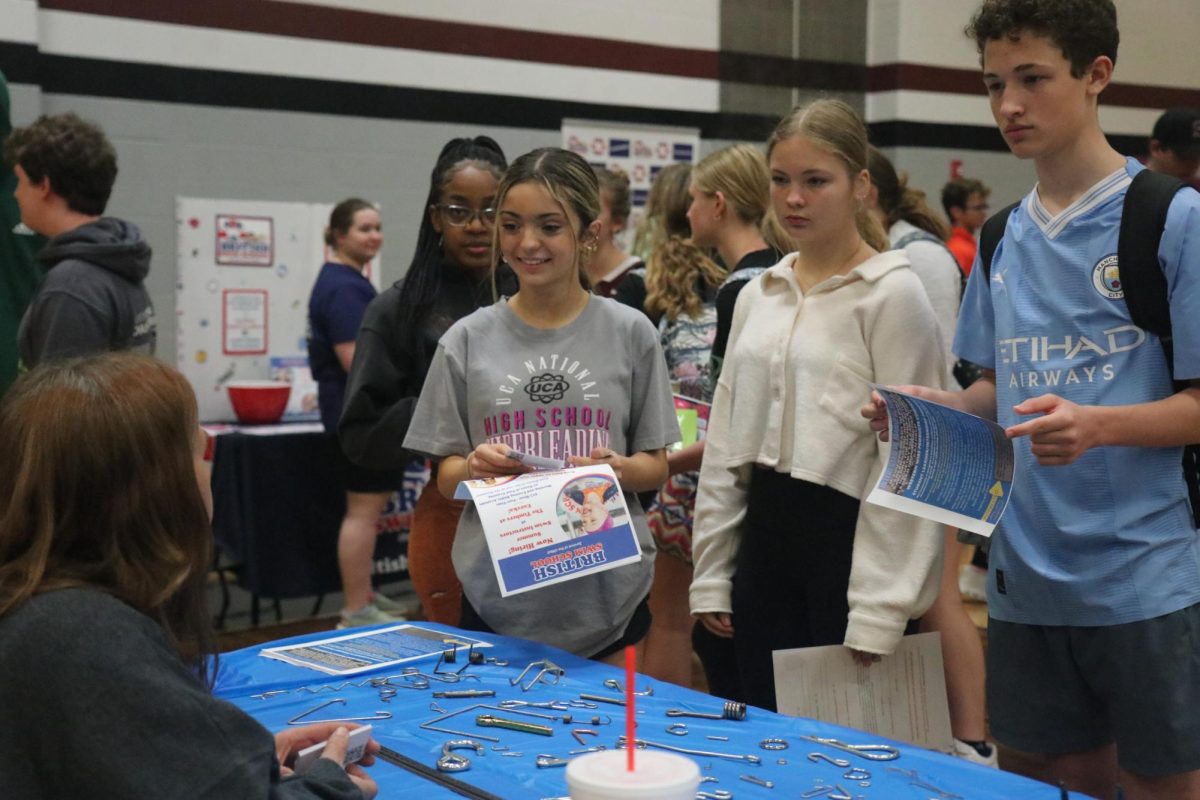 Freshmen London Wallace, Samantha Fadely, Ella Gillick, and Alex Ruffus speak to an employer at the job fair. The job fair took place in the gym on April 10th. 
