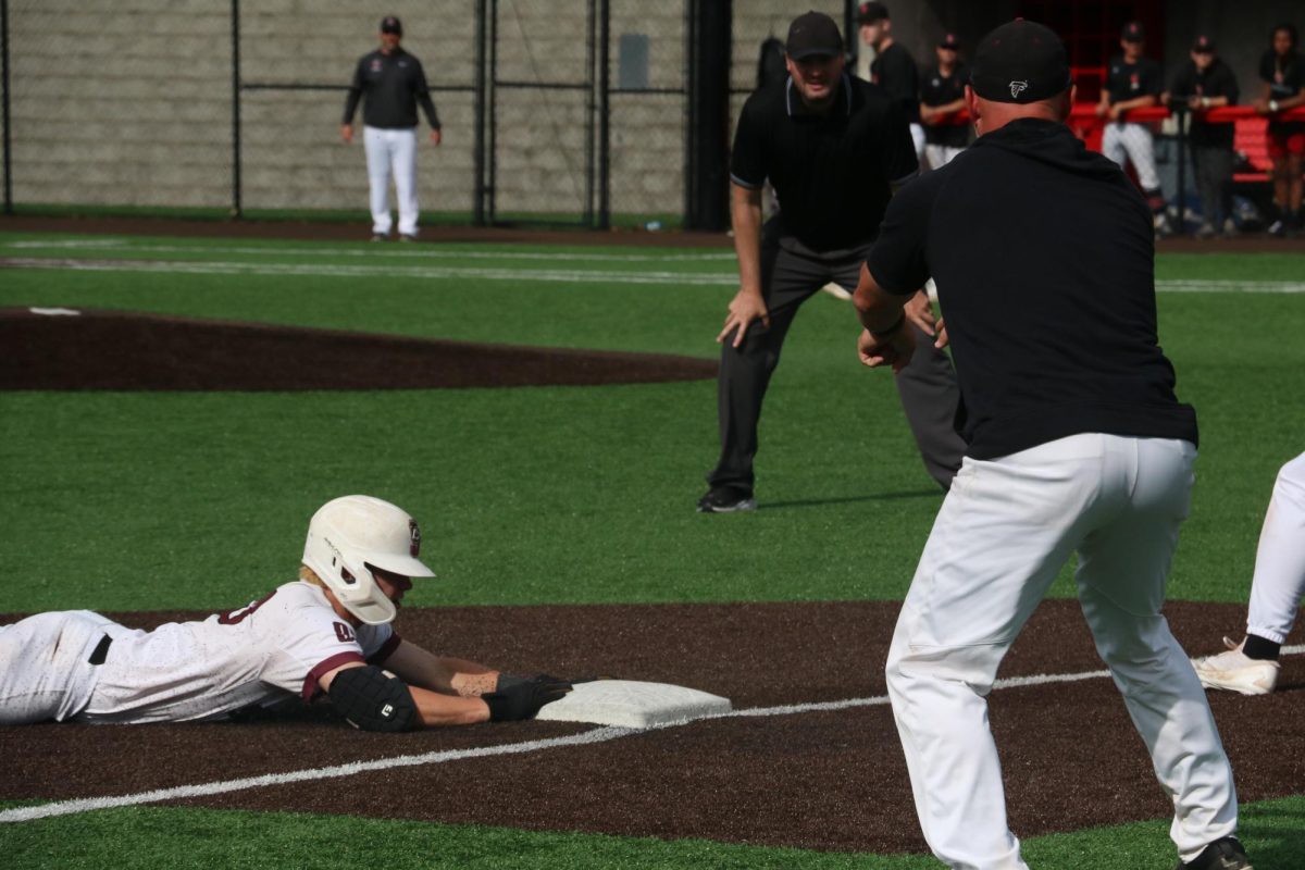 Sliding into the base, junior Jackson Miller secures his position on third.