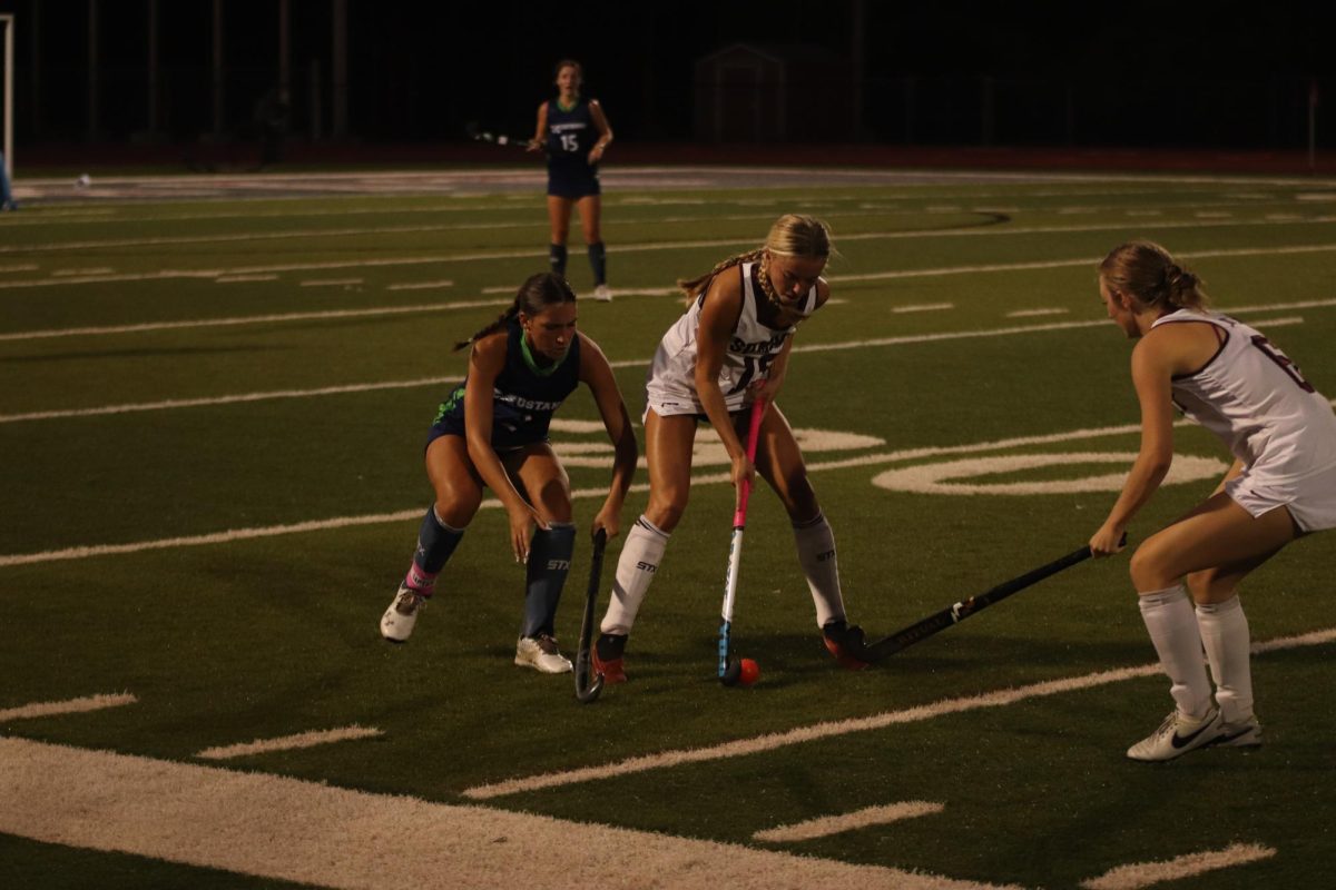 Senior Sienna Nicholson (15) protects the ball from Chloe Ebna (2) of Marquette while Lucy Goellner (6) awaits a pass.