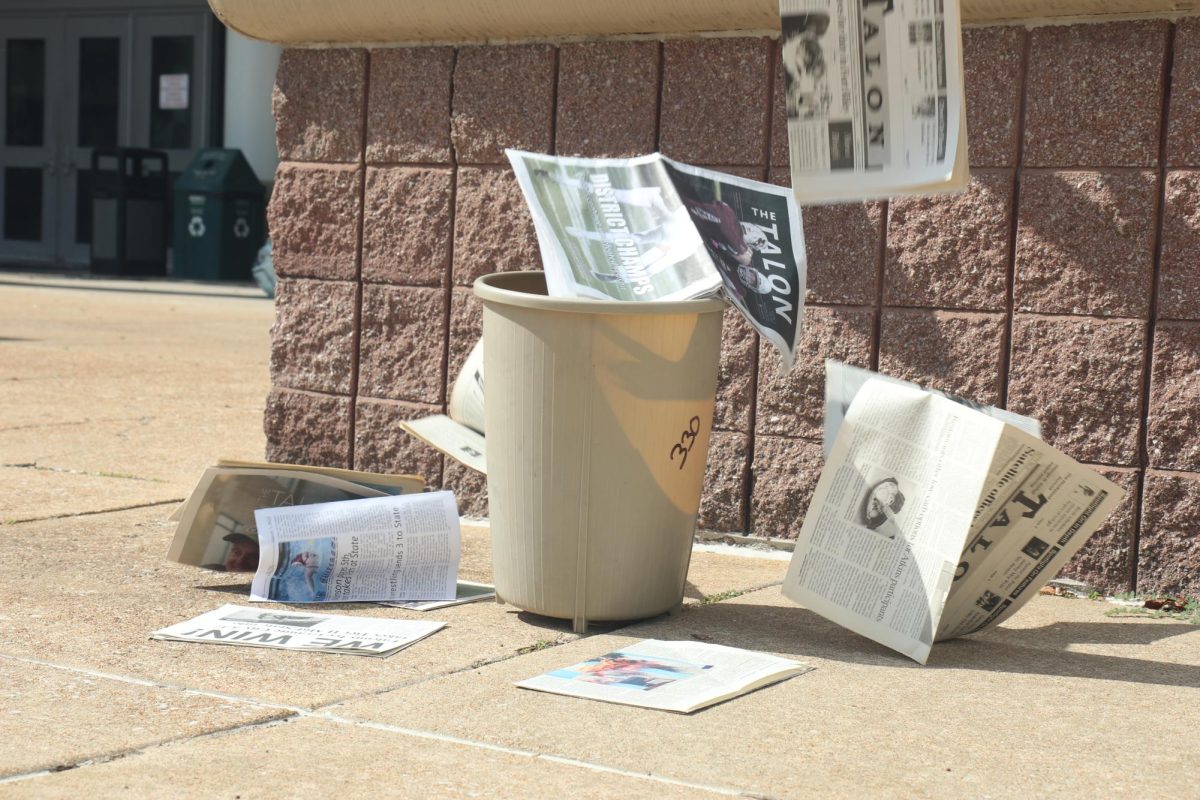 As illustrated, past editions of the Talon are shown 'falling' into an empty trash bin. There are recycling bins in every classroom at Summit, however, they are not utilized to the extent that they should be.
