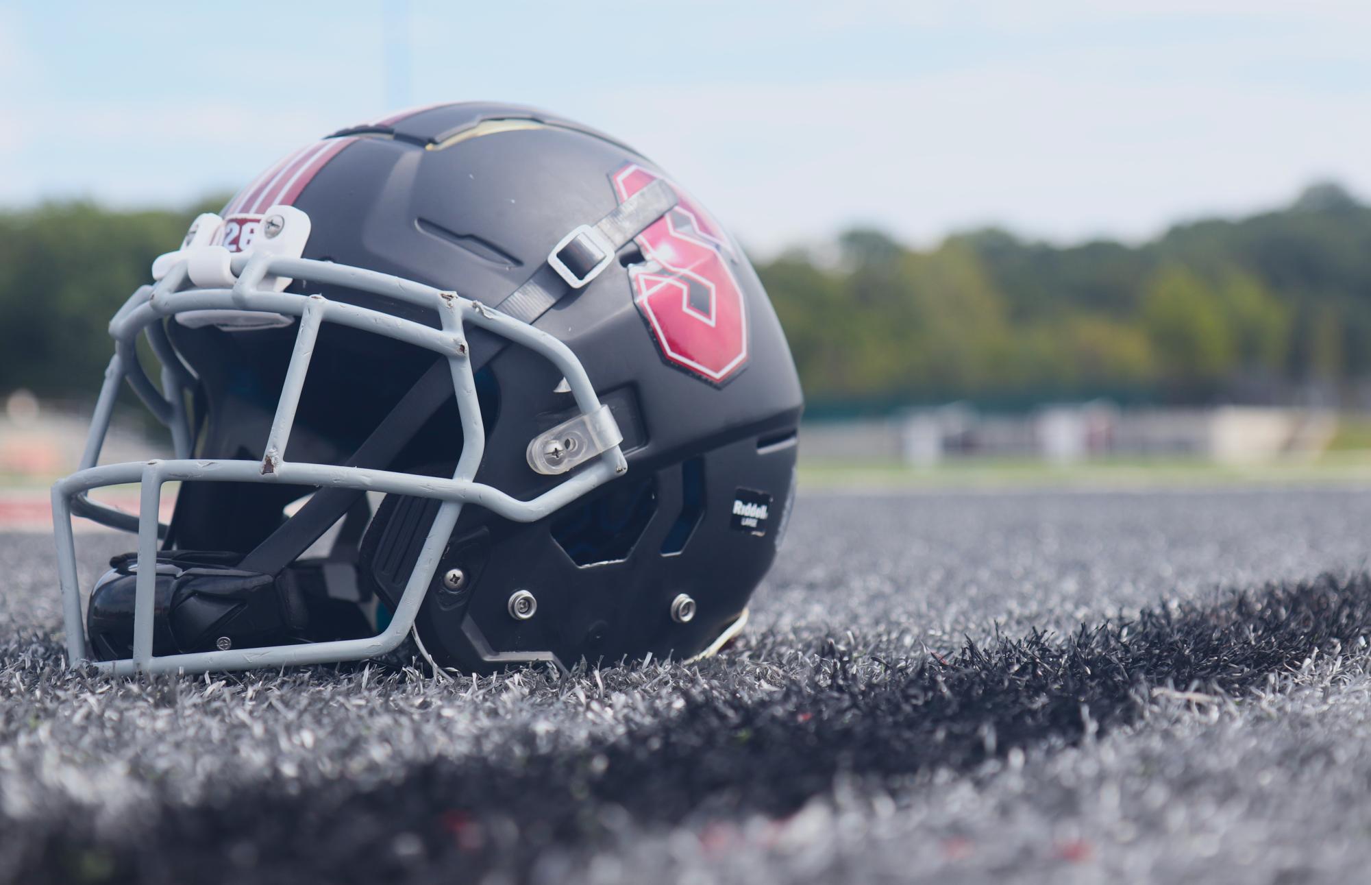 In the illustration, a Summit football helmet sits on the football field. While Summit owns three Guardian Caps, they are not utilized by players. 
