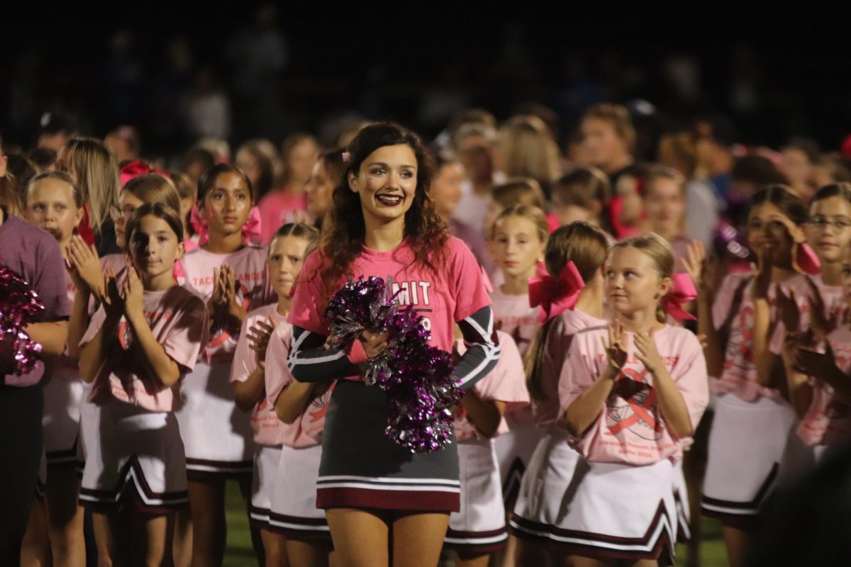 Cheer captain Keegan Thuet appluds the football team after winning the pinkout game.