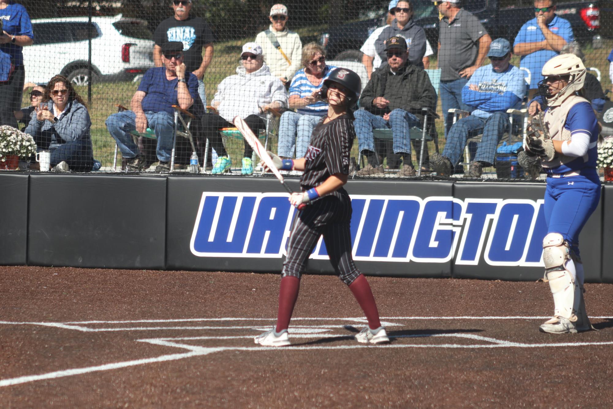 Up to bat, Sophomore Amanda Mehrtens (16) smiles back towards her teammates in the dugout.