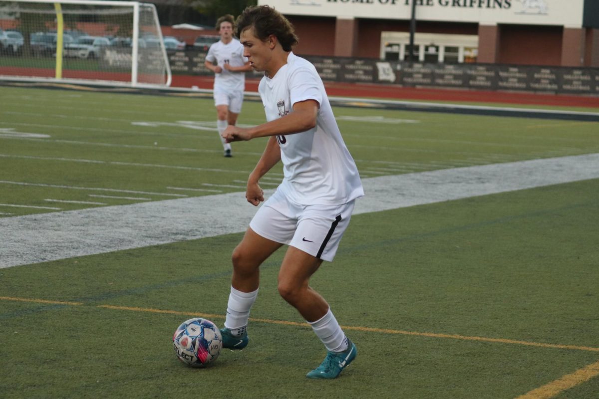 Focusing in on the ball, junior Jack Steele makes his path down the field before making a pass.