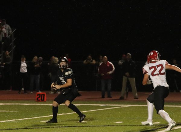 Senior quarterback Blane Branscum tries to find an opening to pass, while sophomore Corbin Fullerton (22) of Fox charges at him.