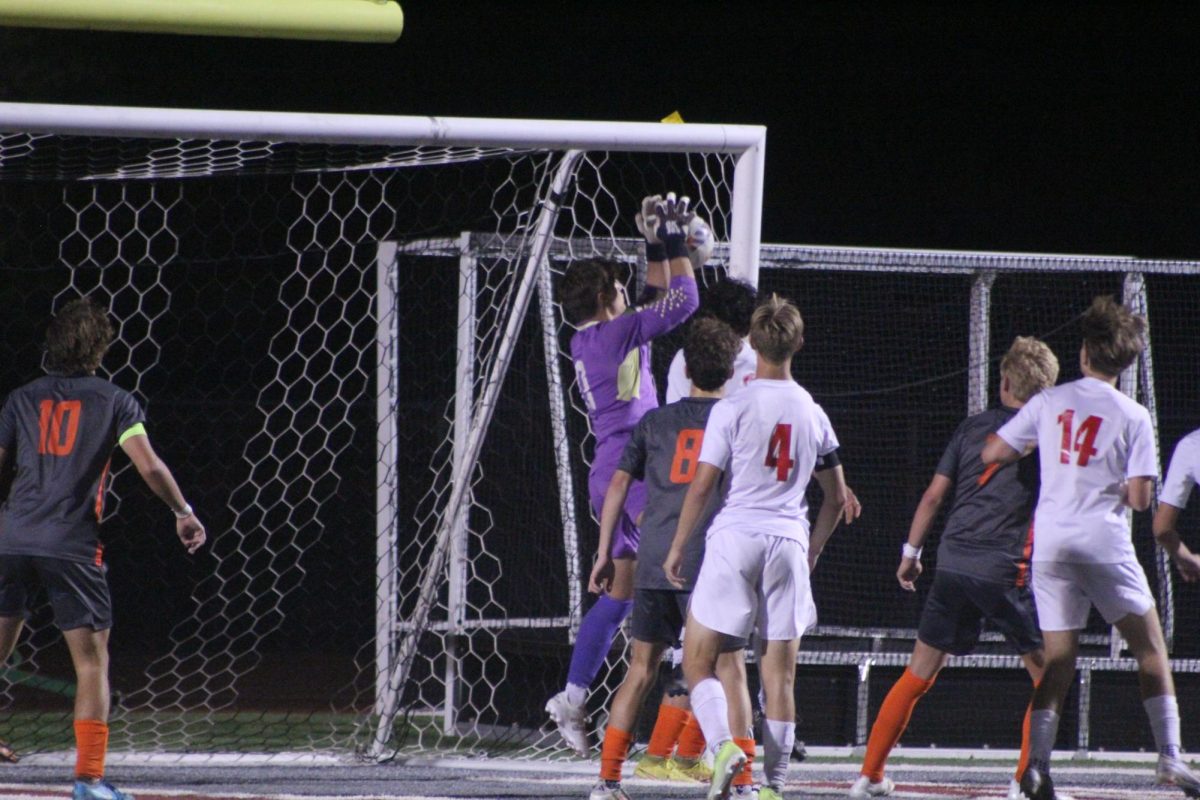 Senior goalie Jack Loffellman saves a goal as juniors Jack Steele (10),  Cade Polsak (8), and Gavin Werner (7) prepare to defend. Senior Dylan Handlan (4) and junior Gabe Kahrhoff (14) of Liberty watch Loffellman's save.