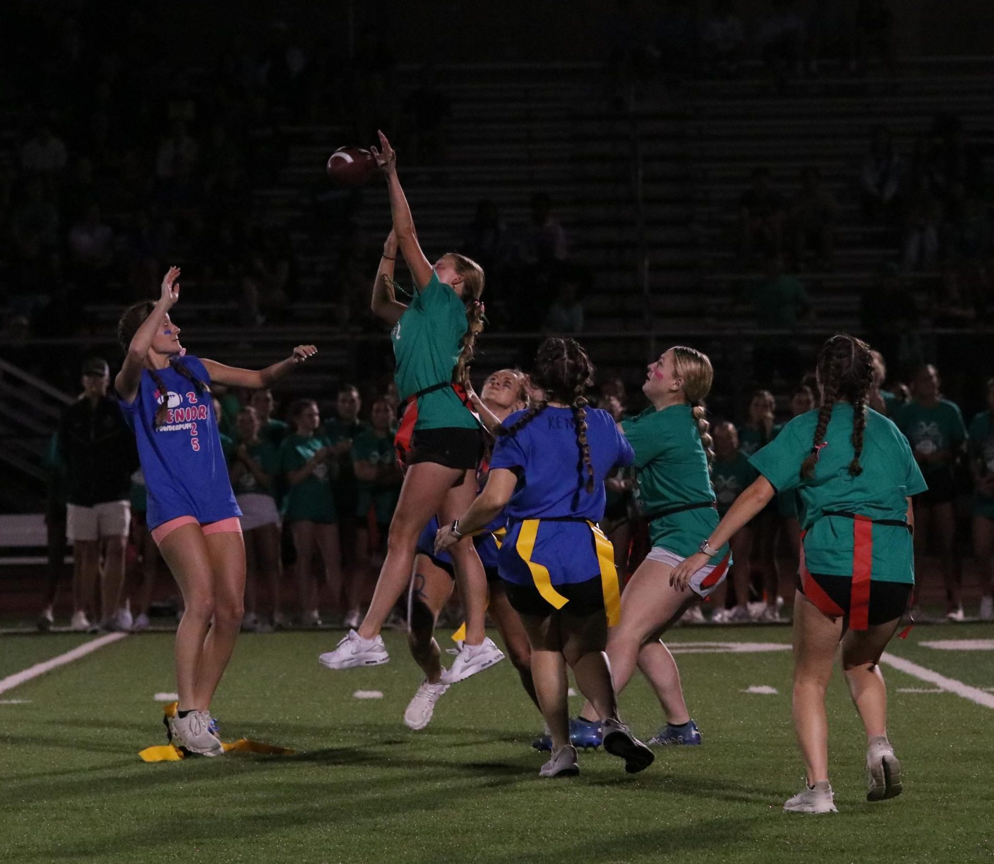 Senior Claire Doyle attempts to stop Junior Kaitlyn Sundhausen from catching the ball as her team mate junior Lorelei Green backs her. The powderpuff game between Summit juniors and seniors took place on Sep 26th.