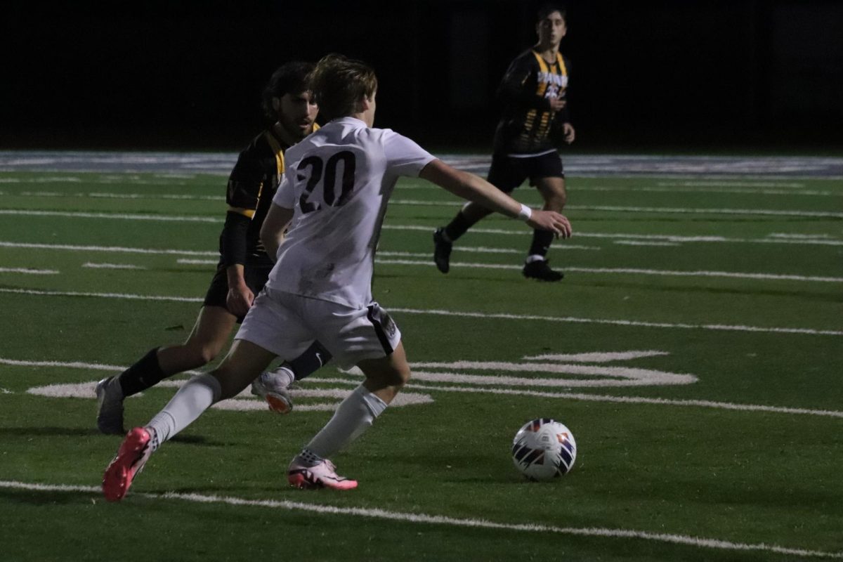 Junior AJ Tuohy (20) fights for the ball while running down the field with Vianney senior Ian Selsor as Vianney senior Logan Russel (26) stands open for a pass.