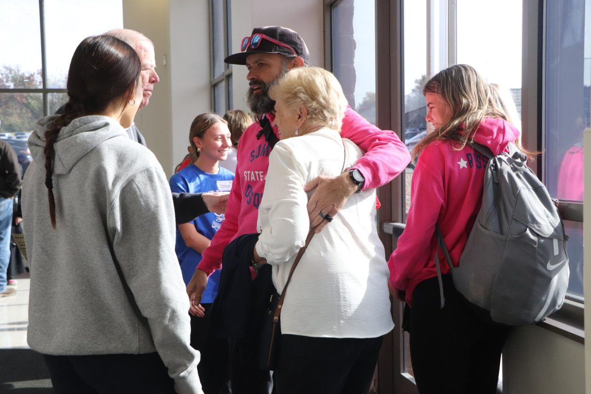 History teacher and track coach, Jason Miller, embraces Janet Sullivan, who was invited by Caterina and Cara Rossomanno to enjoy the veterans luncheon because her husband is a veteran.