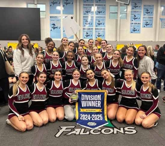 The varsity cheer team smiles with their regional championship award. The team took first place in their division on Nov. 9.