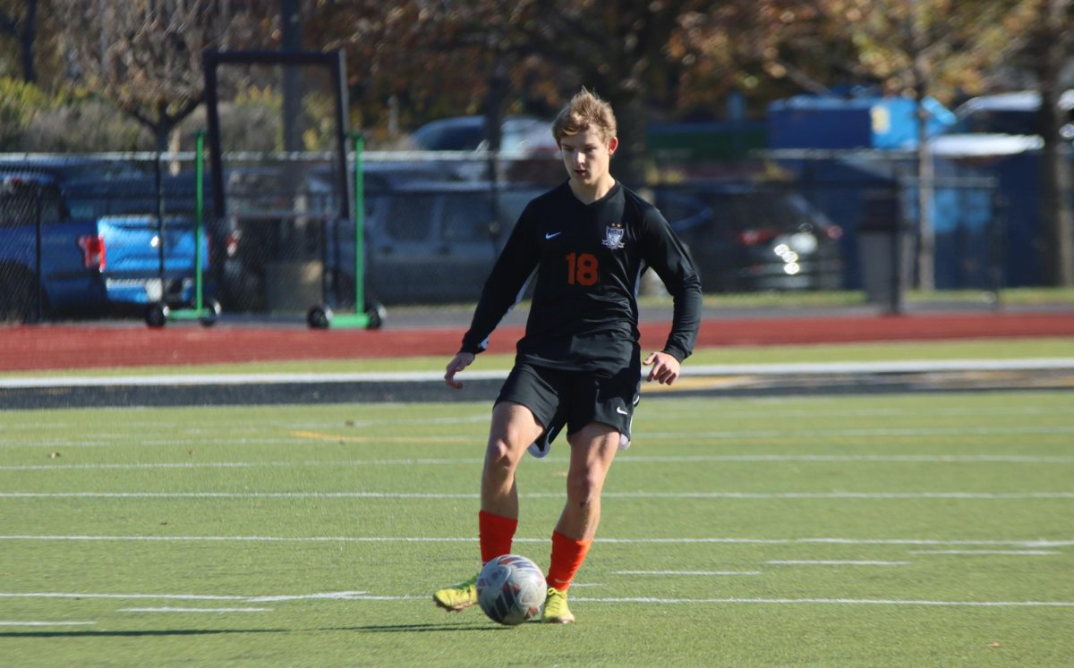 Moving down the field, Junior Wyatt Oetjen prepares to pass the ball to his teammate. The Falcons won 4-0, shutting out the Washington Blue Jays in order to move through the first round of districts. 