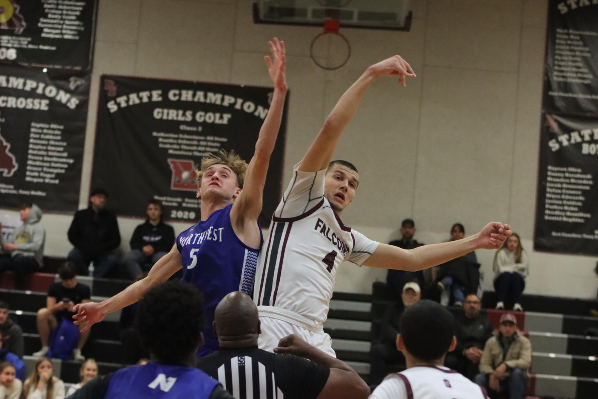 Taking the tip, junior Oliver Puljic (4)battles Northwest’s Ty Hejlek (5) for the ball. The Falcons defeated the Lions 60-34 on Dec. 6.