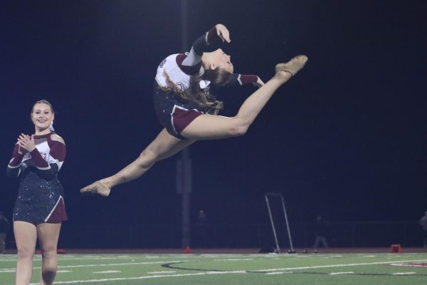 At the senior night football game, senior Nicole Mecey leaps in the air during her feature. Senior night took place on Oct. 18.