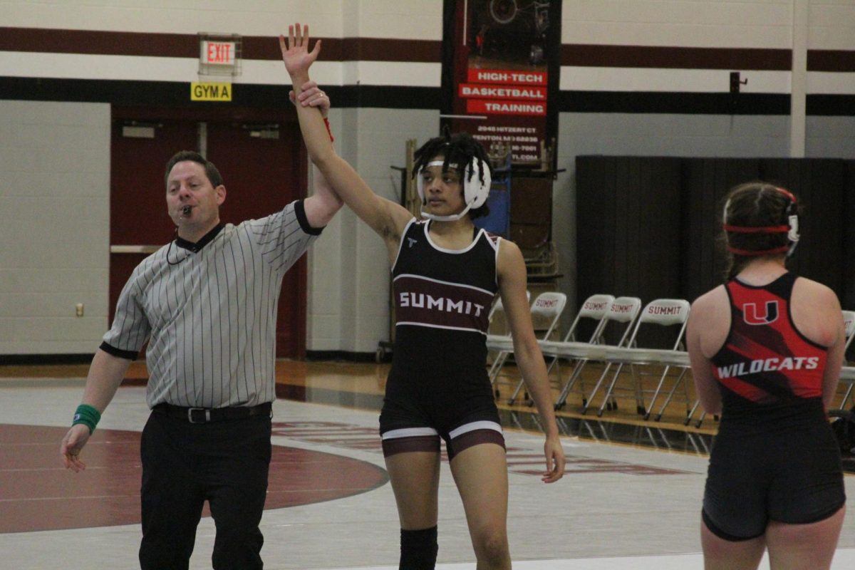 A referee raises freshman Tamara Bohannan's hand after she quickly pinned her opponent.