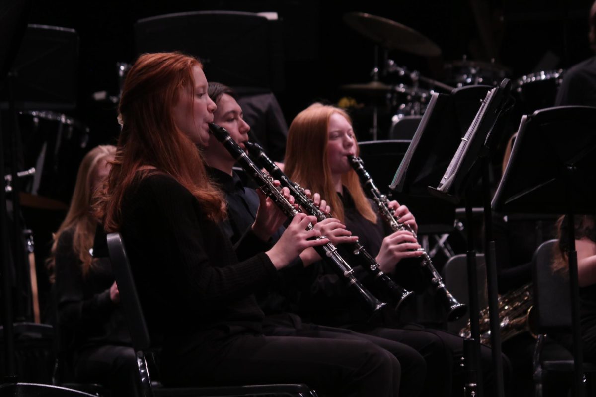 Playing their clarinets, seniors Madeline Kelly and Cameron Mueller and Sophomore Abby Johnson perform at the MMEA Band Concert.