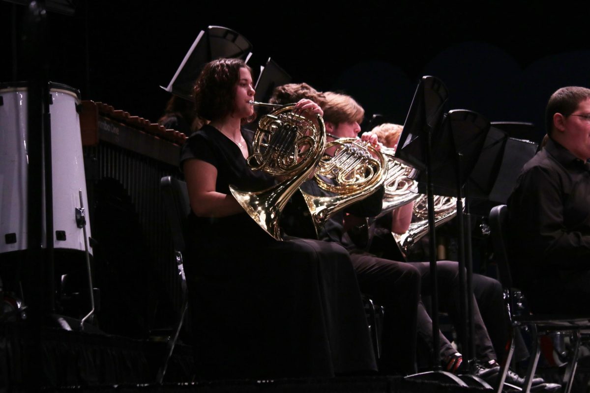 Playing her French Horn, junior Mia Fauss performs during the MMEA Practice Concert.