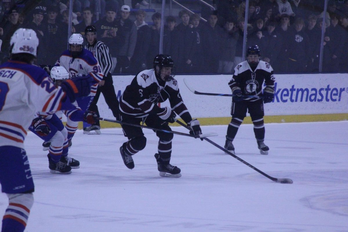 Sophomore Blake Warren (6) carries the puck past a Clayton defender en route for the goal. 