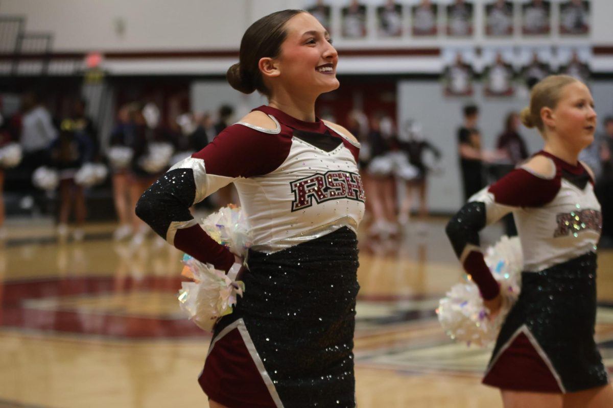 Smiling at the crowd, sophomore Quinn Harness poses with the Silver Stars Dance Team.