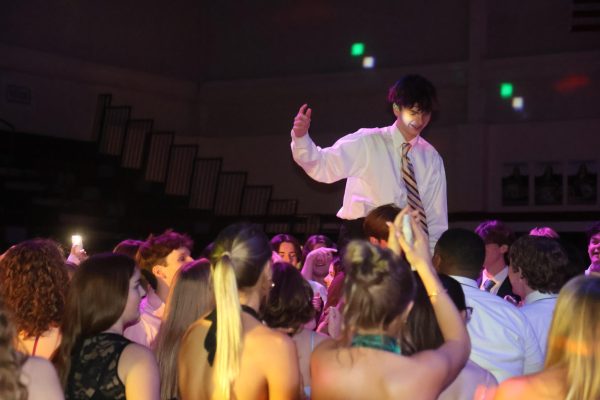 Smiling from atop sophomore Caleb Hardee's shoulders, sophomore Brendan Corkery cheers with the crowd.