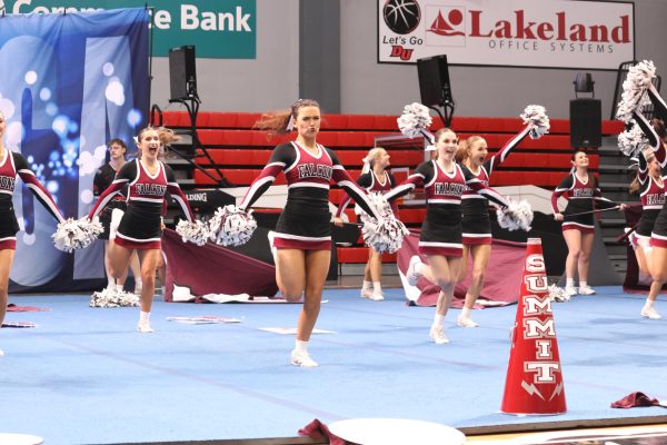 As their routine begins sophomore Elena Marfell, senior Keegan Thuet, and junior Peyton Seifert show spirit while performing.