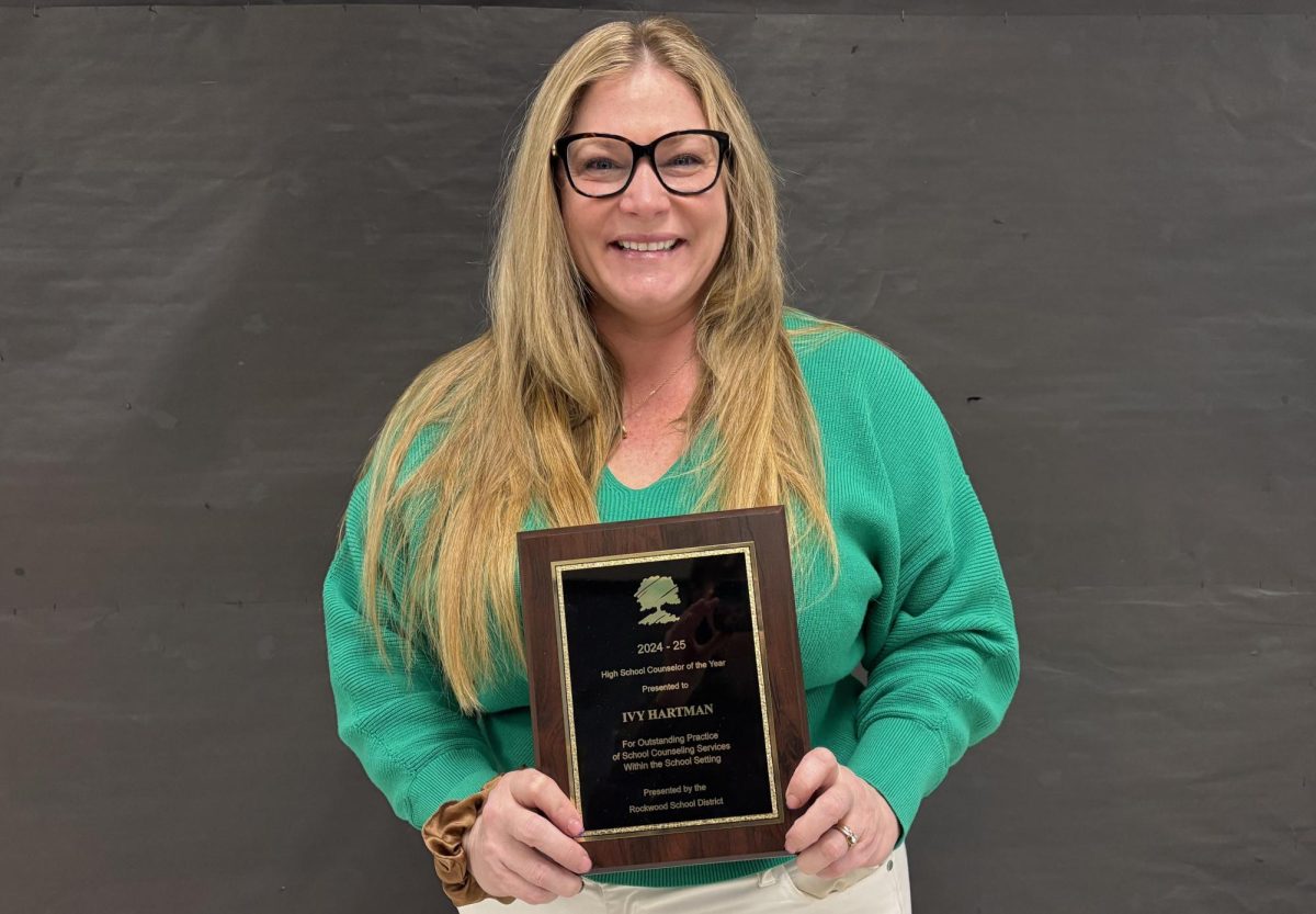 Post-high school counselor Ivy Hartman poses with a plaque awarded to her by the Rockwood School District to recognize her as High School Counselor of the Year. Hartman works with students to develop plans for after graduation.