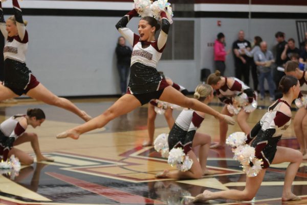 Leaping through the air, freshman Avery Kargacin dances with the rest of the Silver Stars dance team.