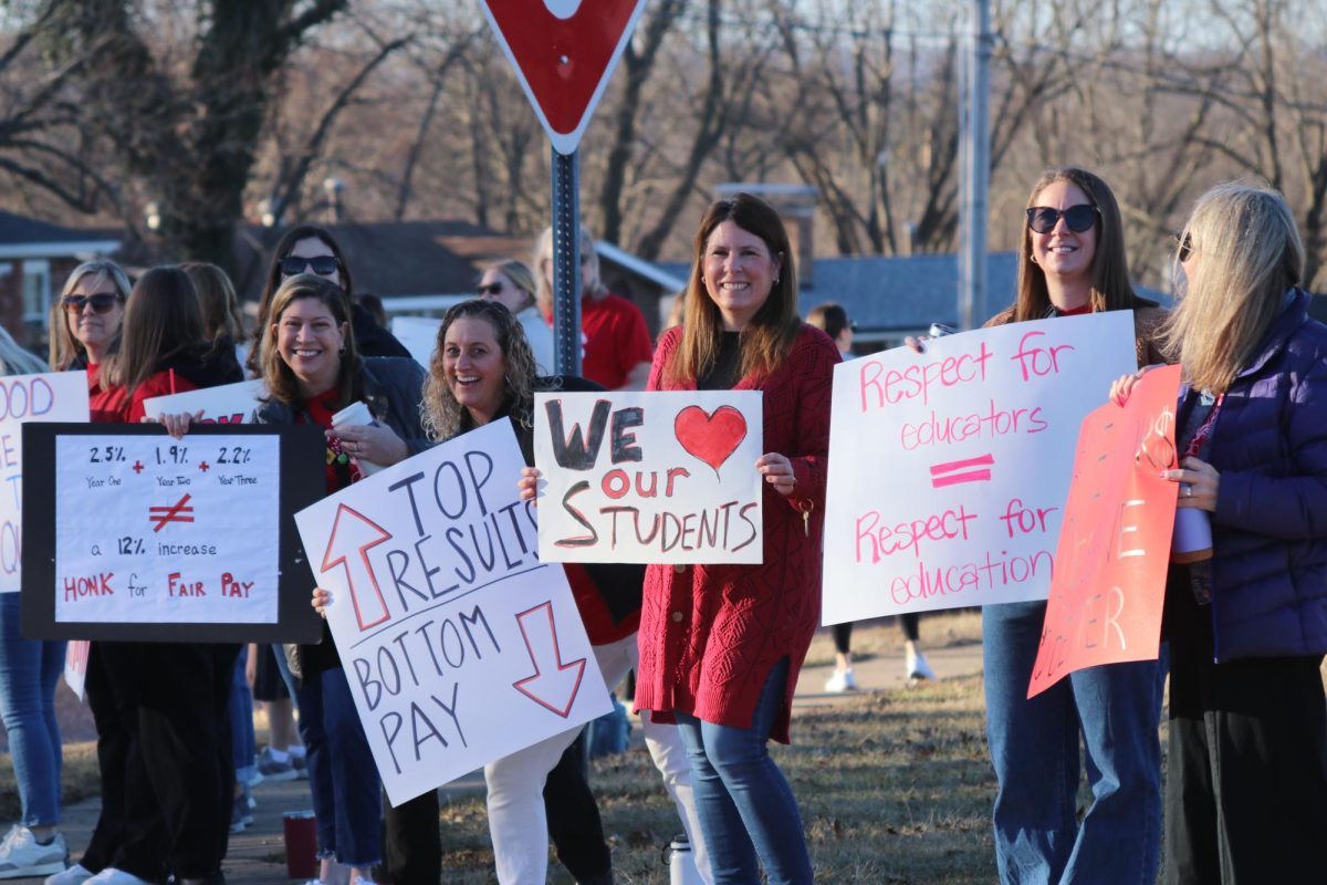 Holding signs on Hawkins Rd., Spanish teachers Kimberly Lackey and Cady Villmer stand next to CTE teacher Laurie Philipp and Guidance Counselor Jessica Kempa. The Coffee at the Curbside event took place on Feb. 25 as educators picketed for higher wages amidst negotiations between the RNEA and the district.