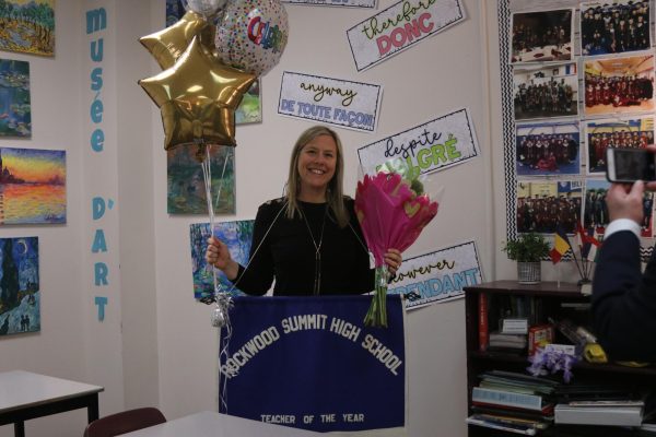 In her 2nd hour AP French class, French teacher Kacey Schlotz smiles after being presented with the Teacher of the Year award and gifts.