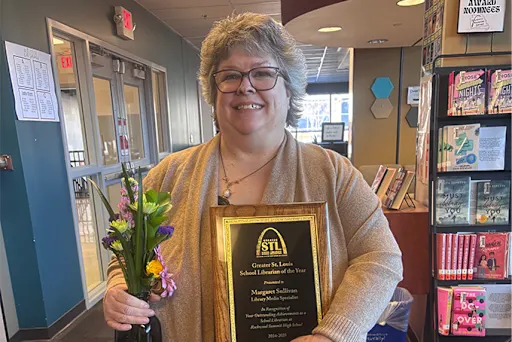 After being gifted flowers and a plaque for her win, Librarian Margaret Sullivan smiles for a photo. (photo from Rockwood School District)