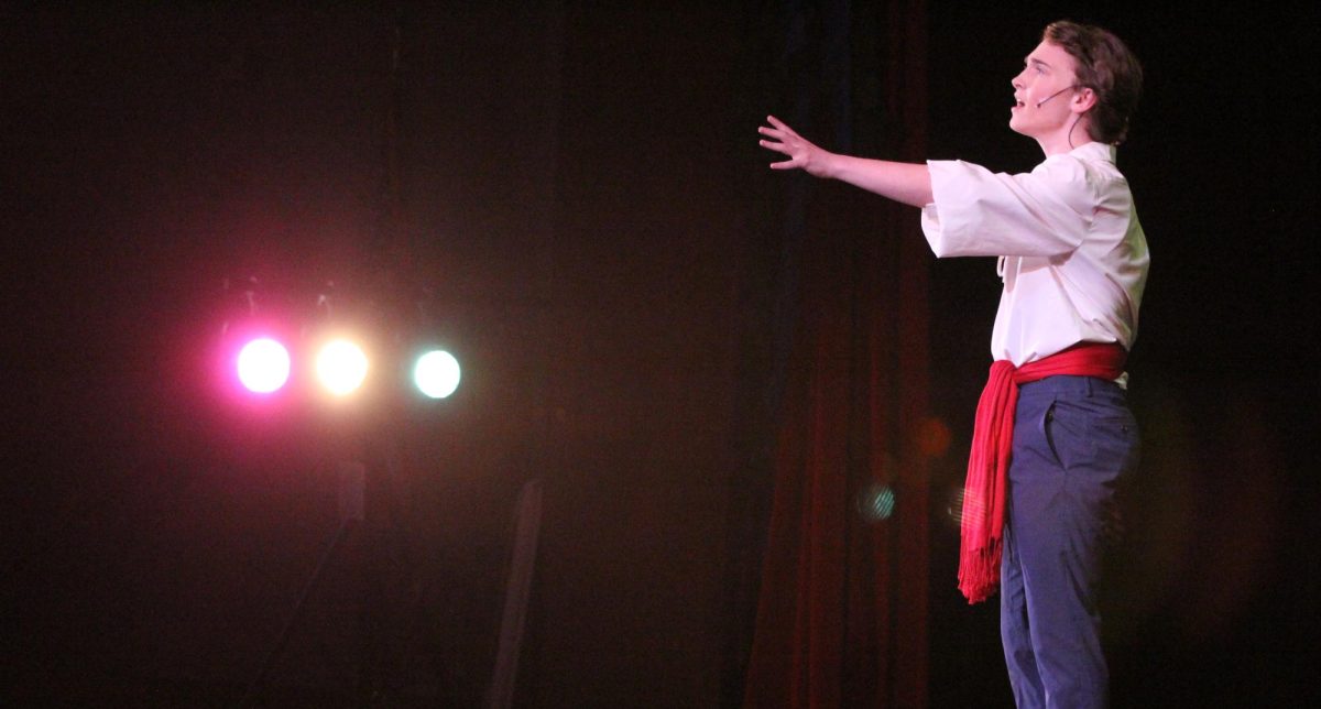 Reaching out to the audience, junior Jackson Schertzer (Prince Eric) performs Eric's solo, "Her Voice," at the dress rehearsal for The Little Mermaid on March 3. The Falcon Players rehearsed for months leading up to their performances.