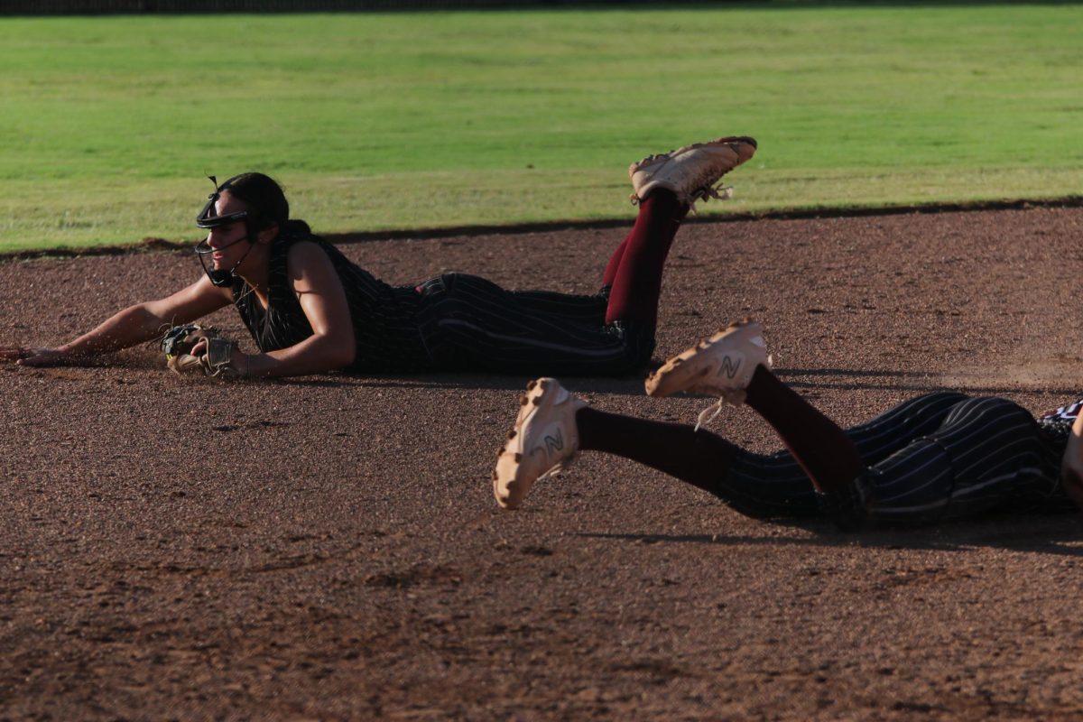 Sliding the third, senior Paige Bray stops a Crusader from stealing a base.