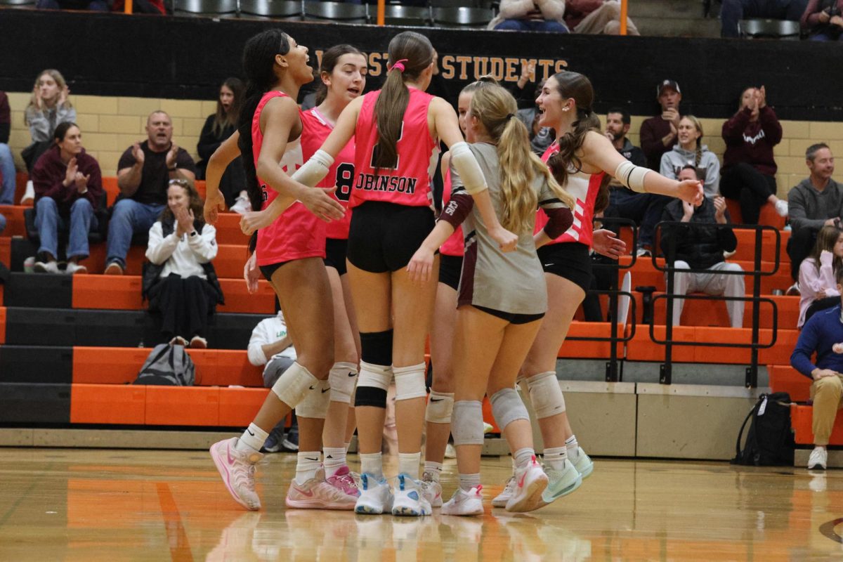 Cheering each other on, the volleyball team celebrates after scoring a point.
