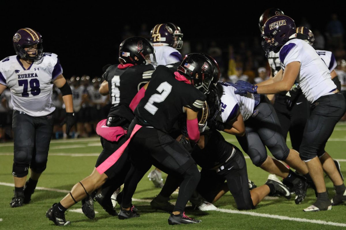 On the field, junior Mason Casso (2) tackles Joe Scotino of Eureka, with the help of senior Aidan Amy (6). The team lost to the Wildcats Oct. 3 with a score of a 28-7. As of Oct. 21 Casso holds the title of the most interceptions in the state with seven. 