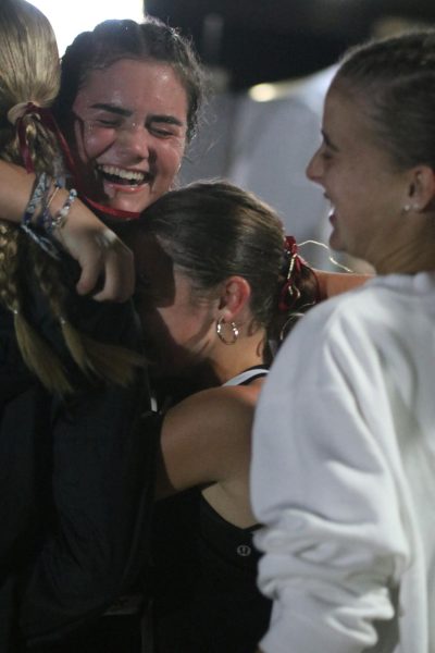 Celebrating her success, sophomore Audrey Struckhoff embraces her teammates, sophomore Mya Perstrope, along with freshmen Olivia Backer and Natalie Liberto at the finish line. Struckhoff broke her all-time personal record by under a minute, finishing at 22:41.60 and placing 229th in the Varsity Girls A-Elite division race.